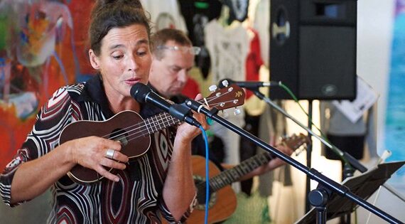 Im Bild ist ein Konzert von Secret Song Service mit Edda an Ukulele und Mikro, Ralph an der Gitarre
